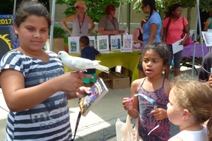 Image of girl holding a dove on her finger during a library event