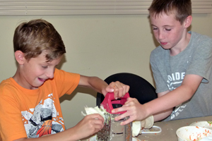 Image of two boys grating cheese at a library event