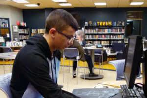 investigación adolescente Un adolescente trabajando con un ordenador