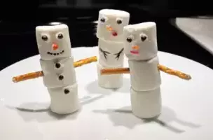 Snowmen made out of marshmallows and pretzel sticks for arms