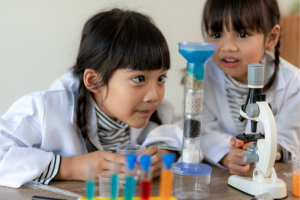 Discovery Science Two children looking at a science beaker in awe