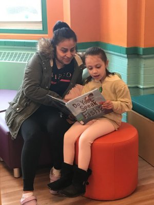 SPD Reading Parent reading a book to her child at the new Sadie Peterson Delaney African Roots Library