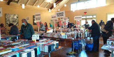 Shoppers at the Friends of PPLD Holiday Book Sale browsing books on tables.